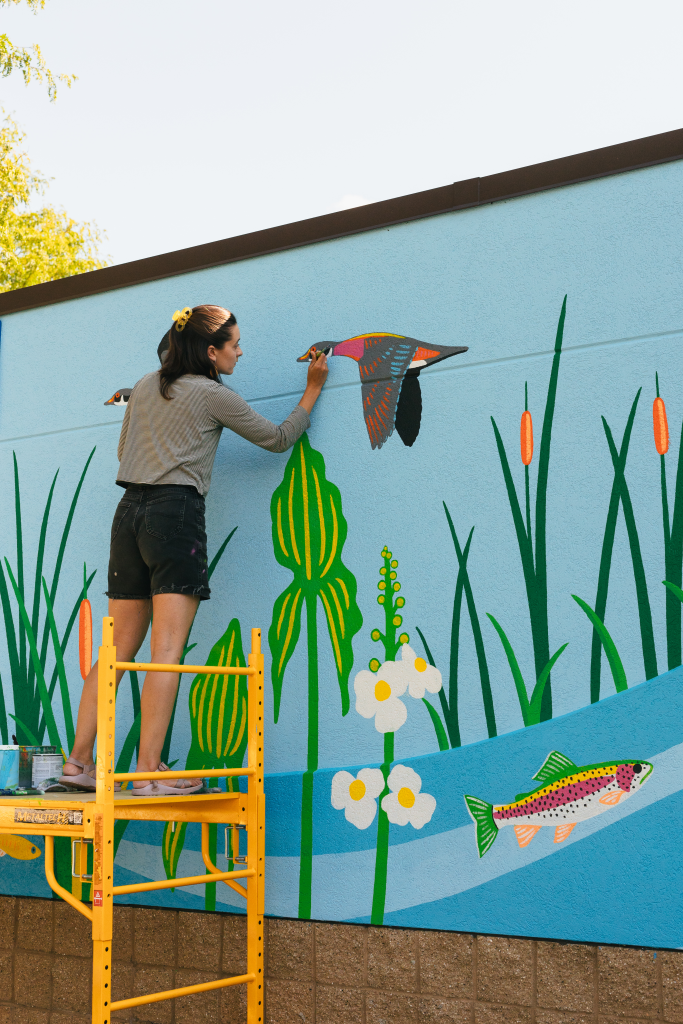 Artist Natalie Hinahara painting her mural at Bauman Community Pool in Middleton Wisconsin